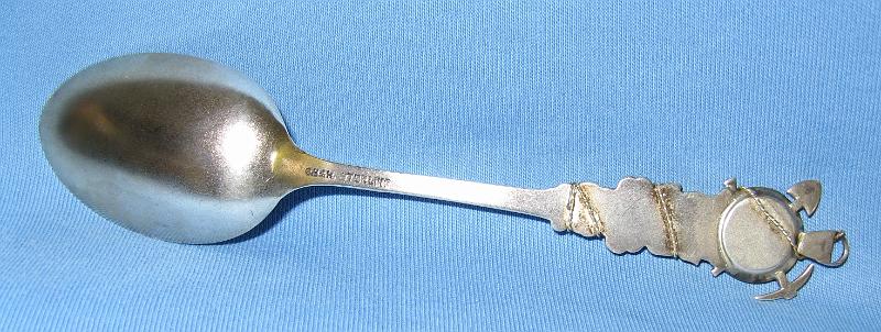 Souvenir Mining Spoon Back Deadwood SD.JPG - SOUVENIR MINING SPOON DEADWOOD SD - Sterling silver spoon with engraved bowl showing miner panning for gold and marked DEADWOOD S.D., figuralhandle with gold pan, pick, shovel and ore bucket on top with rope wrappingthe top of handle, 5 3/8 in. long, reverse marked Sterling with CB&H hallmark for Codding Brothers & Heilbron, North Attleboro, MA who made sterling flatware from 1879-1918, Heilbron became a partner in 1891 [Deadwood, South Dakota was established in 1876 during the Black Hills gold rush. The settlement of Deadwood began illegally on land which had been granted to the Lakota-Sioux.  In 1875, a miner named John B. Pearson found gold in a narrow canyon in the Northern Black Hills. This canyon became known as "Deadwood Gulch," because of the many dead trees that lined the canyon walls at the time. The name stuck.  Today Deadwood has a population of 1270 residents and serves as the county seat of Lawrence County.  In 1874 a government- sponsored expedition confirmed the presence of gold in the Black Hills. The U.S. government tried to conceal the discovery from the general public in order to honor the 1868 Treaty of Fort Laramie, which forever ceded the Black Hills to the Lakota-Sioux. Despite the efforts of the military and federal government, the American populace learned about the discovery of gold in the Black Hills. Influenced by dreams and greed, the 1876 gold rush was on in the Black Hills. Once Deadwood was established, the mining camp was soon swarming with thousands of prospectors searching for an easy way to get rich. Most of the early population was in Deadwood to mine for gold, but the lawless region naturally attracted a crowd of rough and shady characters. These particular individuals made the early days of Deadwood rough and wild. A mostly male population eagerly patronized the many saloons, gambling establishments, dance halls, and brothels. By late 1877, Deadwood was moving from a primitive mining camp to a community with a town government, wood and brick buildings, and a sense of law and order. As the economy changed from gold panning to deep mining, Deadwood lost its rough and rowdy character. The town survived two devastating fires, one in 1879 and another in 1894, each time to rebuild.  In 1890, the Fremont, Elkhorn, and Missouri Valley Railroad connected the town to the outside world.  With the railroad, Deadwood evolved into a prosperous commercial center primarily focused on its gold mining industry.  South Dakota entered statehood on November 2, 1889 and Deadwood became the place where people traveled in the Black Hills to conduct their business, settling into the twentieth century.  Deadwood became the only city in the United States to be named a National Historic Landmark in 1964. A state initiative authorized legalized gaming in Deadwood to start on November 1, 1989. The introduction of gaming has enabled Deadwood to preserve its historic buildings and dramatically increase tourism. The lure of gaming is not the only draw to Deadwood; people are also fascinated by its unique, colorful history.]